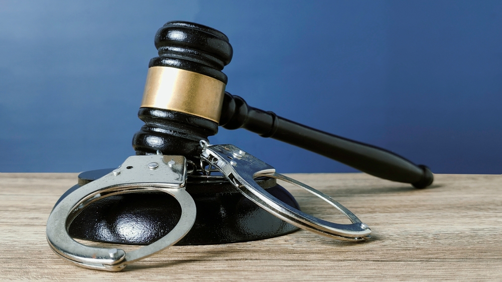 Gavel and handcuffs on a table, representing New Jersey hit and run charges and leaving the scene of an accident defense.
